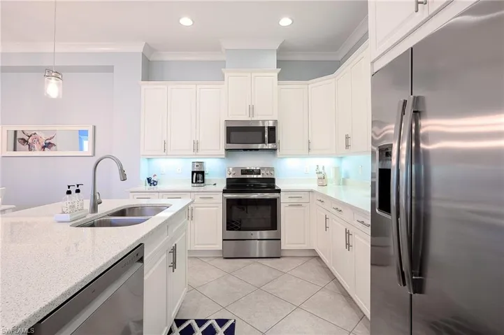 Kitchen with sink, crown molding, appliances with stainless steel finishes, and light tile patterned flooring
