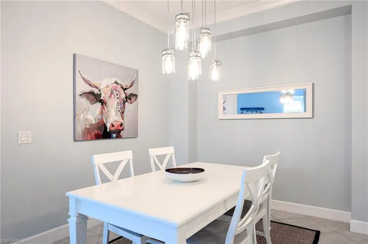 Tiled dining space featuring crown molding