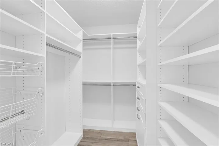 Walk in closet with light wood finished floors