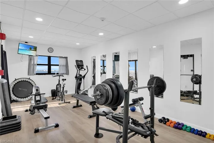 Gym featuring a paneled ceiling and recessed lighting