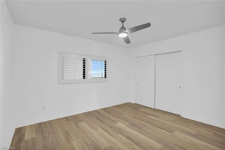 Unfurnished bedroom featuring light wood-style flooring, a closet, and ceiling fan