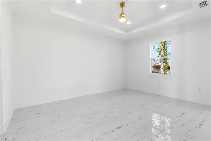 Unfurnished room with ceiling fan, light marble finish floors, and recessed lighting