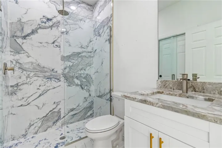 Bathroom with a marble finish shower and vanity