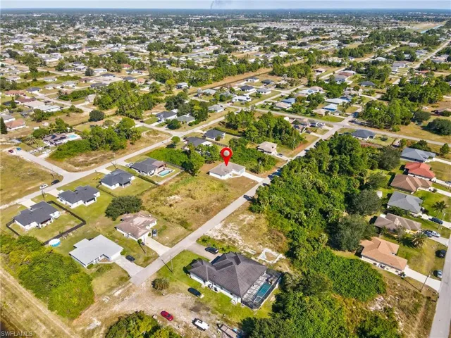 Aerial view of property and surrounding area with nearby suburban area
