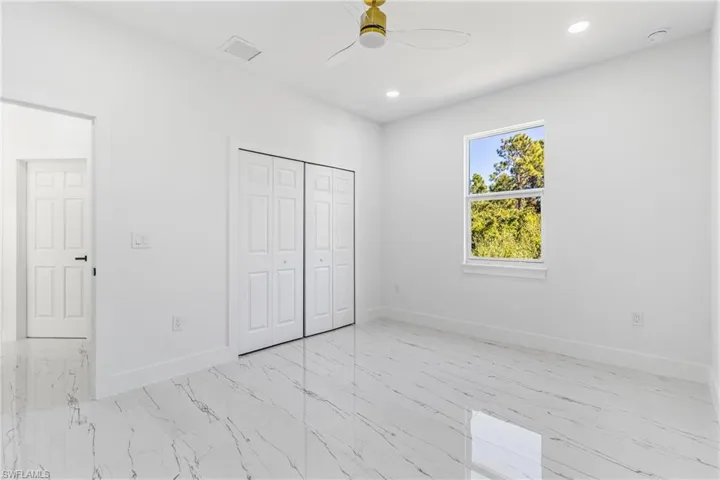 Unfurnished bedroom with recessed lighting, ceiling fan, a closet, and light marble finish flooring