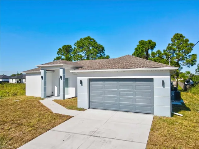 View of front of home featuring a front yard, stucco siding, driveway, a shingled roof, and an attached garage