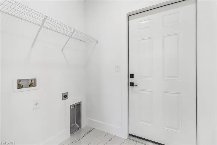 Laundry room with electric dryer hookup, washer hookup, and light marble finish floors
