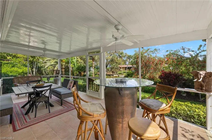 View of patio with a ceiling fan, outdoor dining space, and a sunroom