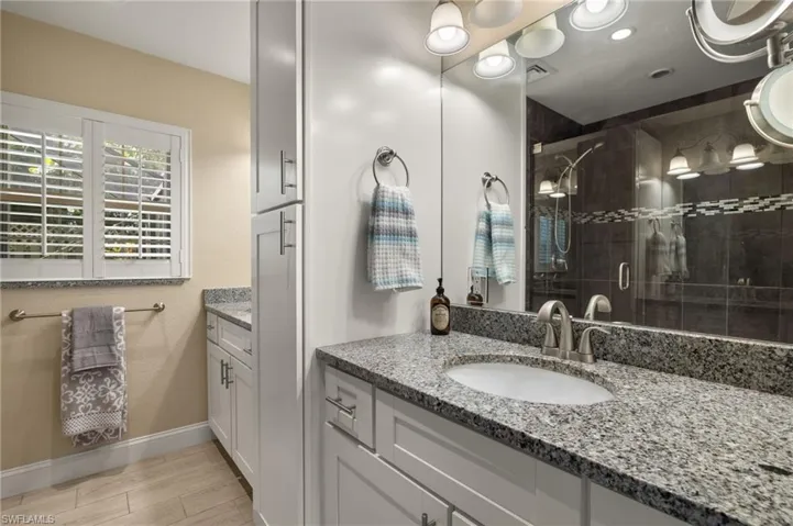 Bathroom featuring vanity, a shower stall, and light wood finished floors