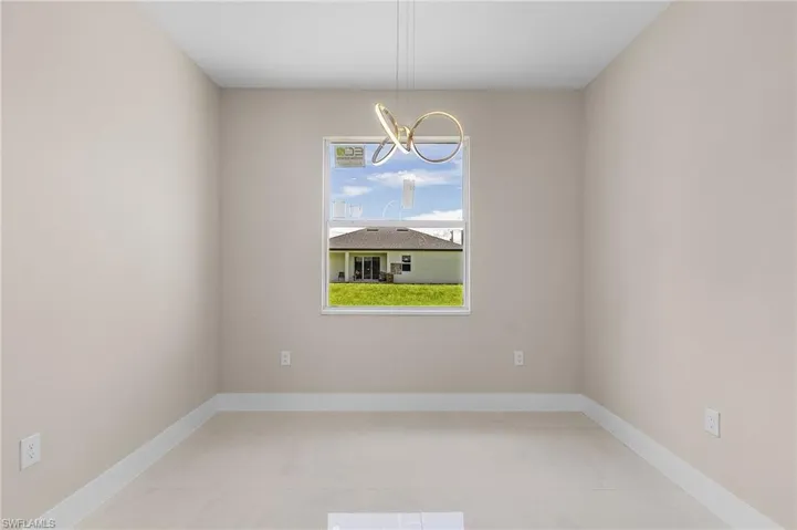 Spare room with tile patterned floors and a chandelier