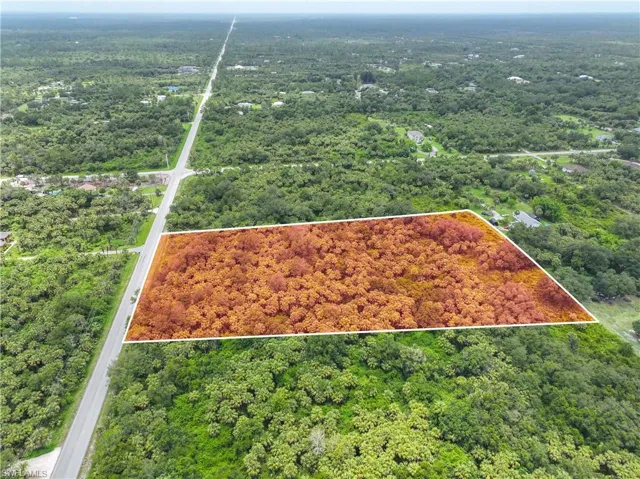 Aerial view of property's location featuring a heavily wooded area and property parcel outlined