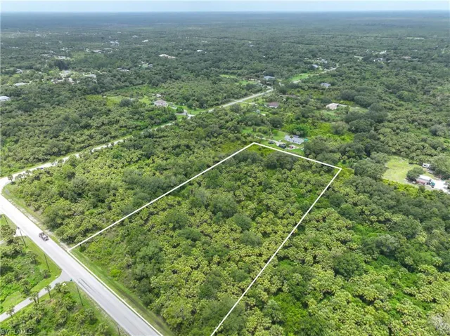 Aerial view of property's location with property boundaries highlighted and a heavily wooded area