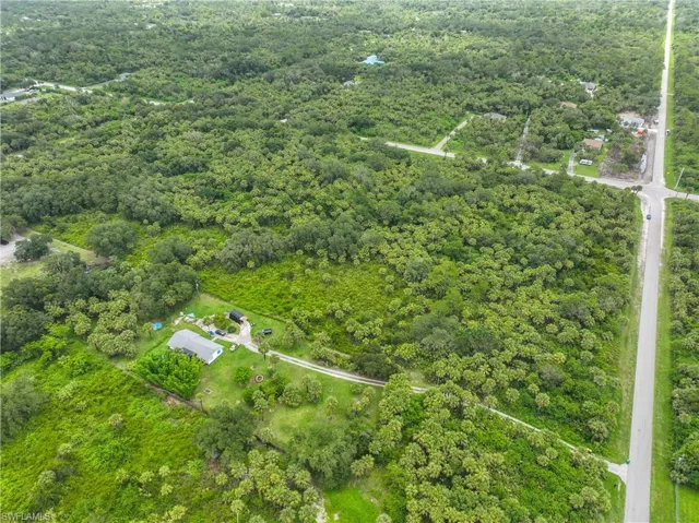 Aerial view of property's location with a heavily wooded area