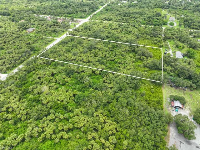 Aerial view of property's location with property parcel outlined and a forest