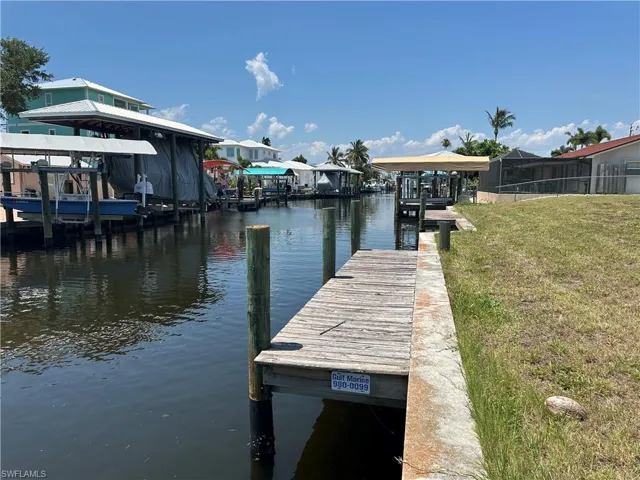 View of dock with a yard and a water view