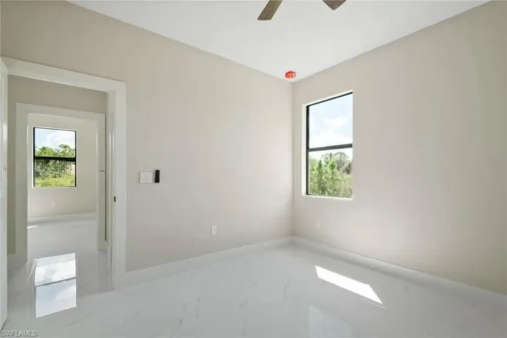 Spare room featuring ceiling fan and light marble finish floors