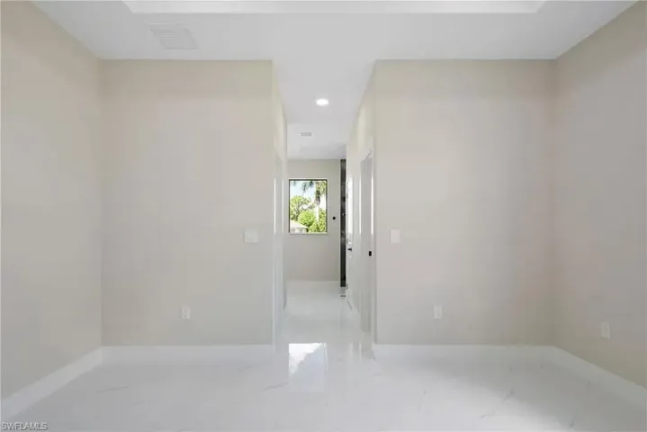 Unfurnished room featuring recessed lighting and light marble finish flooring