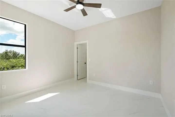Empty room featuring baseboards and ceiling fan