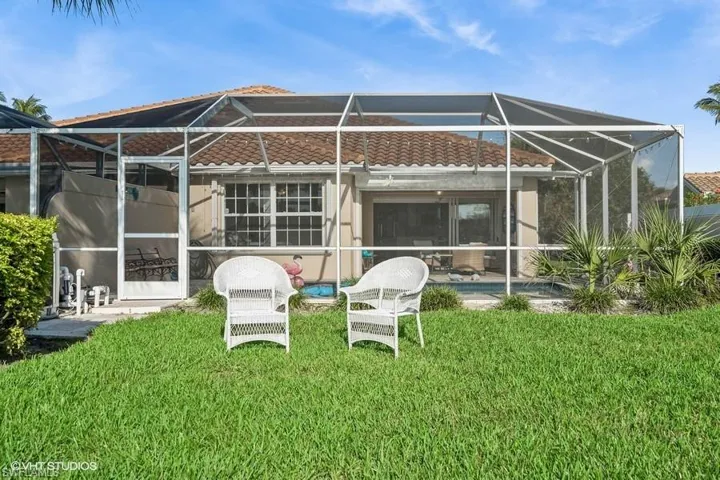 Rear view of house with a yard, a lanai, and a patio area