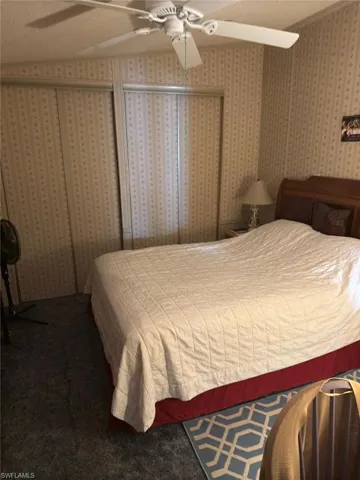 Bedroom featuring ceiling fan, carpet floors, and a textured ceiling