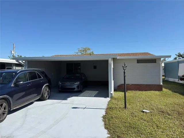 Single story home featuring a front lawn and a carport
