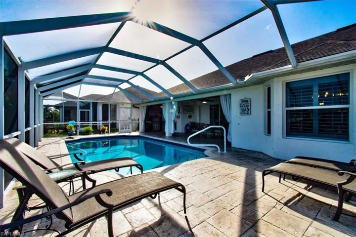 Outdoor pool featuring a patio area, screen enclosure.