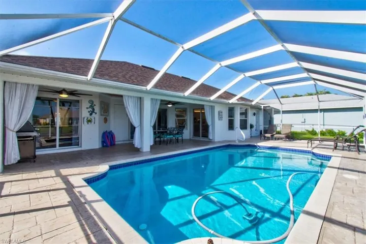 Swimming pool featuring a patio area, a covered lanai, and a ceiling fan