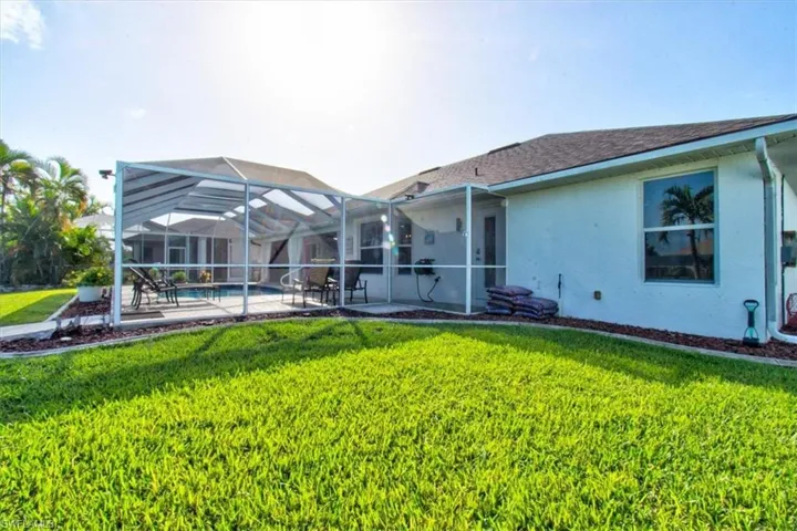 Back of property featuring screen enclosure, lanai and saltwater pool
