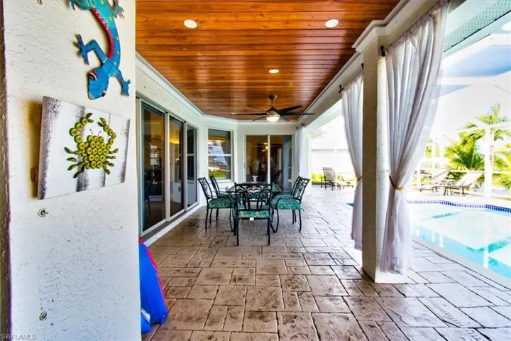 View of patio featuring outdoor dining space, an outdoor pool, ceiling fan, and wood ceiling.