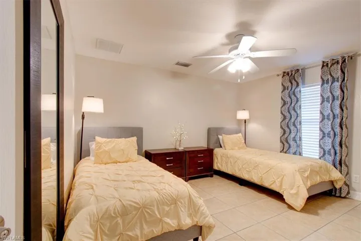 Bedroom featuring light tile patterned floors and a ceiling fan