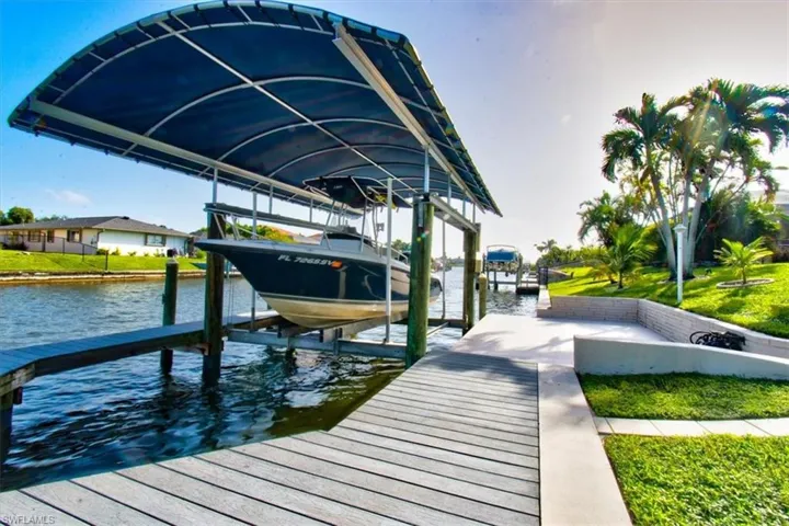 Dock featuring boat lift and a water view
