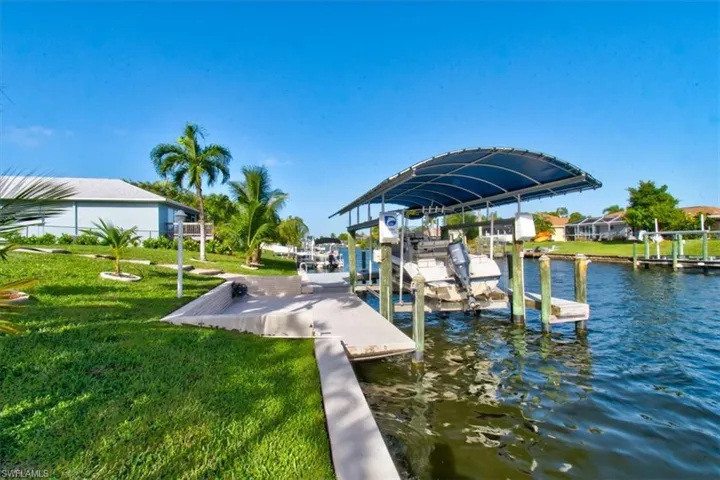 Dock with a yard, boat lift, and a water view