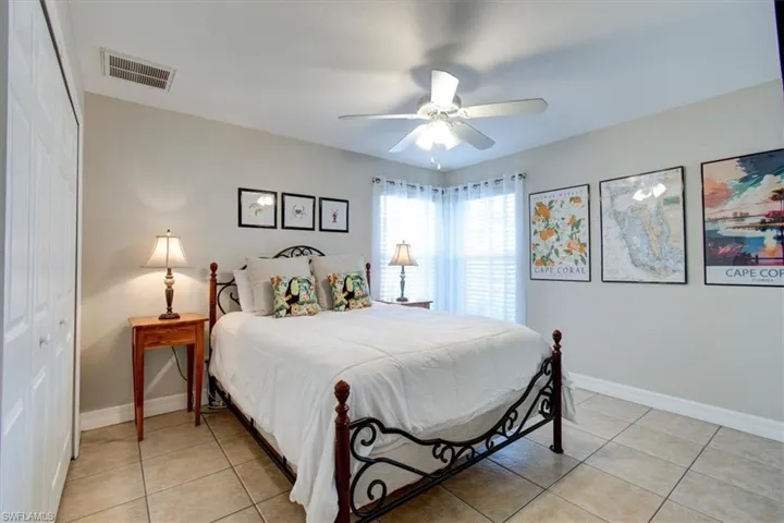 Bedroom featuring a closet, light tile patterned flooring, and ceiling fan
