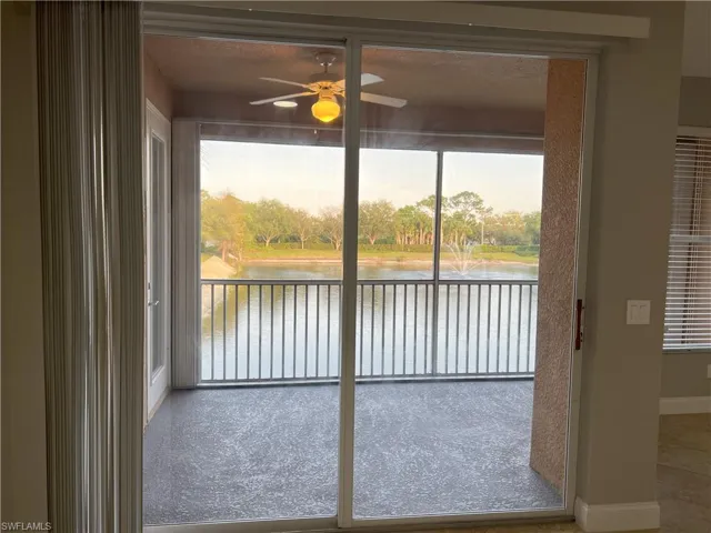 Doorway with plenty of natural light, baseboards, a water view, and ceiling fan