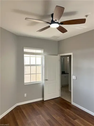 Unfurnished bedroom with dark wood finished floors, visible vents, and baseboards