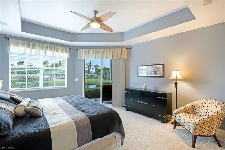 Primary bedroom with access to the large, screened lanai with a view of the lake.