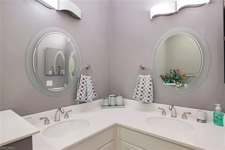 Primary bathroom has dual sinks and decorative mirrors.