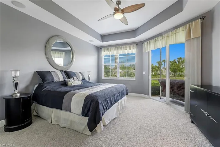 Large primary bedroom with view of the lake and access to the screened lanai.
