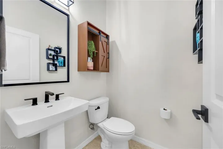 Half bathroom with toilet and light tile patterned floors