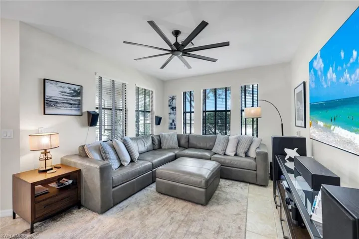 Living area featuring light tile patterned floors and a ceiling fan