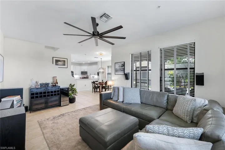 Living area featuring light tile patterned floors and ceiling fan