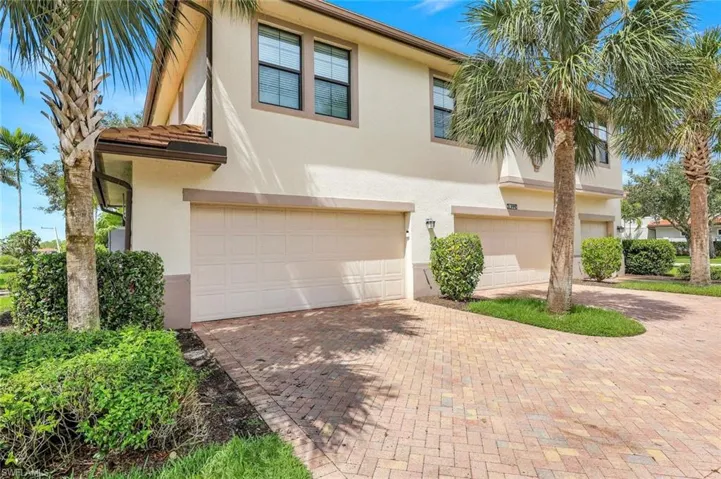 View of front of house featuring stucco siding, an attached garage, and decorative driveway