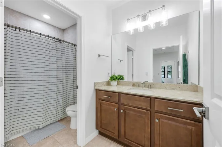 Bathroom with vanity, light tile patterned floors, a shower with curtain, and recessed lighting
