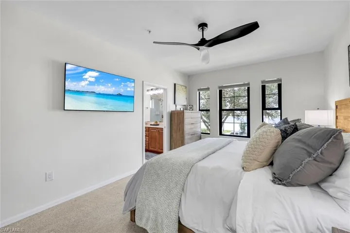 Bedroom with carpet flooring, ceiling fan, and ensuite bath