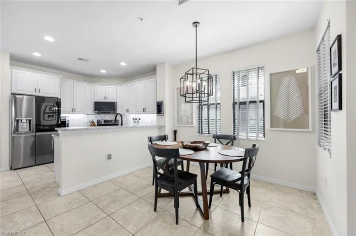 Dining space with a chandelier, recessed lighting, and light tile patterned flooring