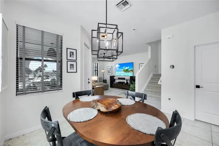 Dining area with stairway and light tile patterned floors