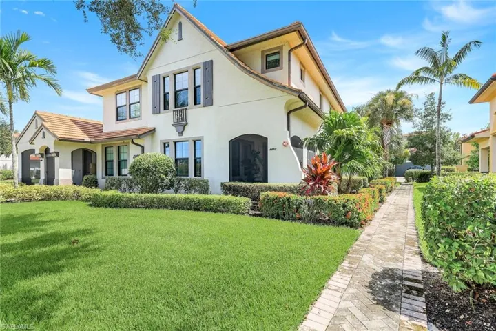 Rear view of property with a lawn and stucco siding