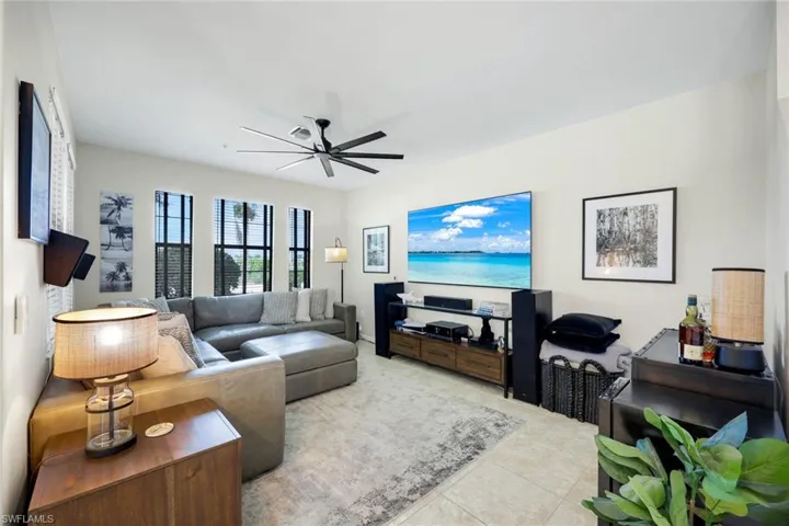 Living area featuring a ceiling fan and tile patterned flooring