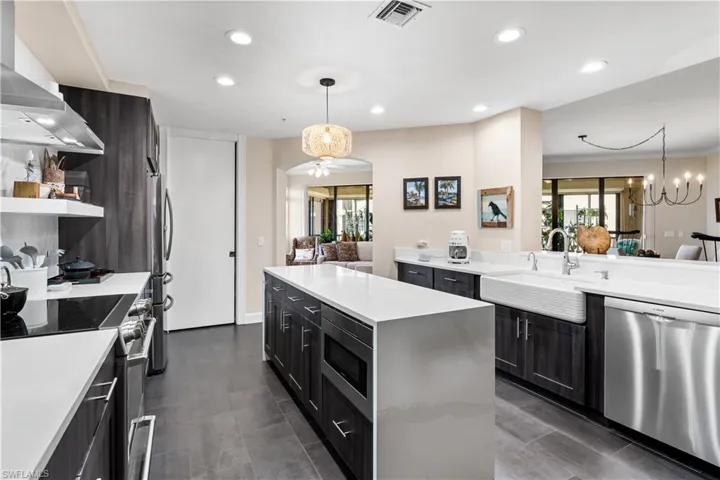 Complete kitchen remodel with quartz countertops, waterfall island, farm sink. SS appliances. Microwave is built into the island foreground.