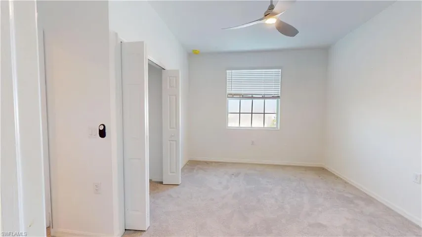 Unfurnished bedroom featuring light colored carpet and ceiling fan